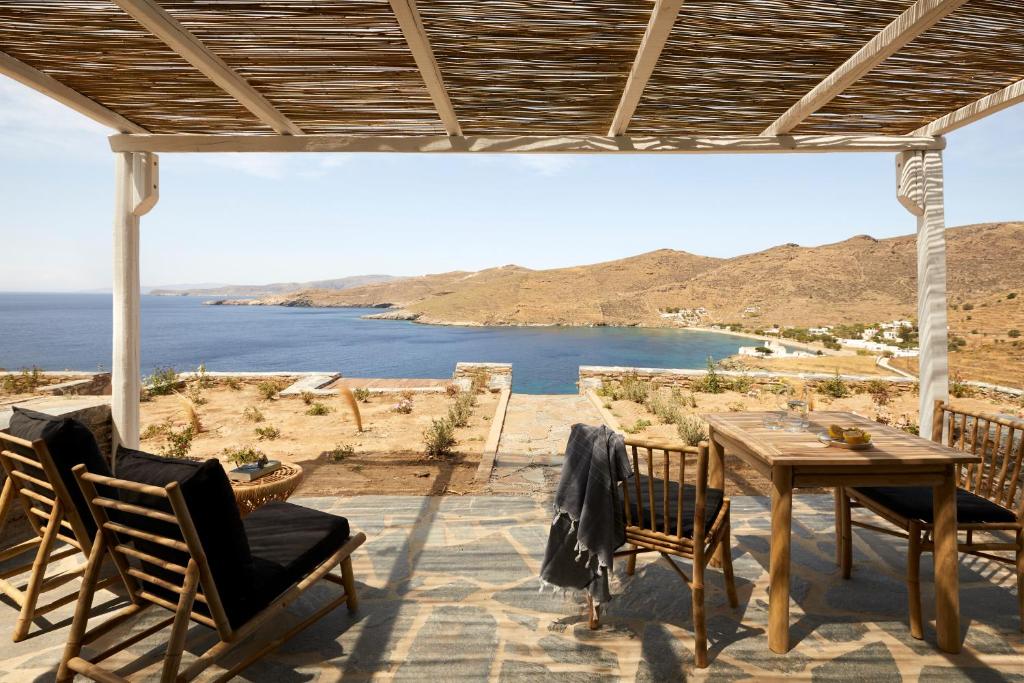 un patio con mesa y sillas y vistas al océano en Stimata, en Kithnos