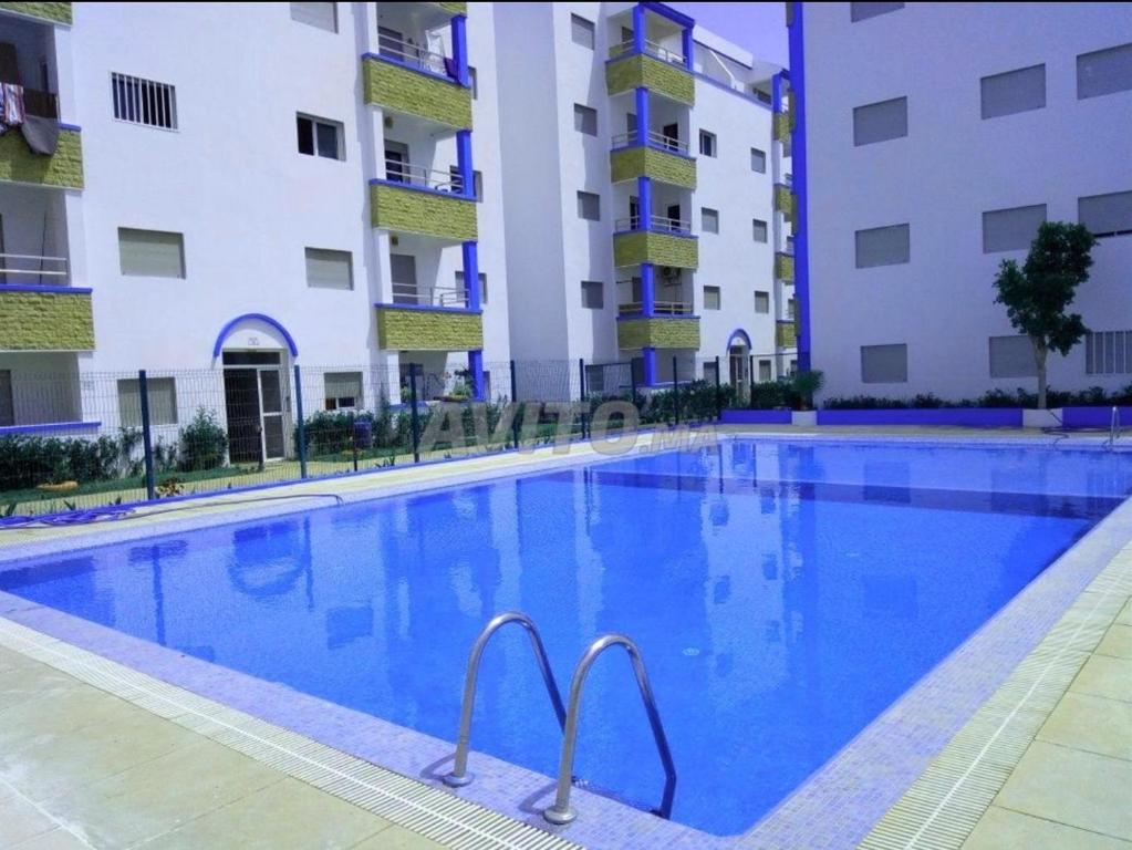 Oued Laou的住宿－Appartement à OUED LAOU - TETOUAN，大楼前的游泳池