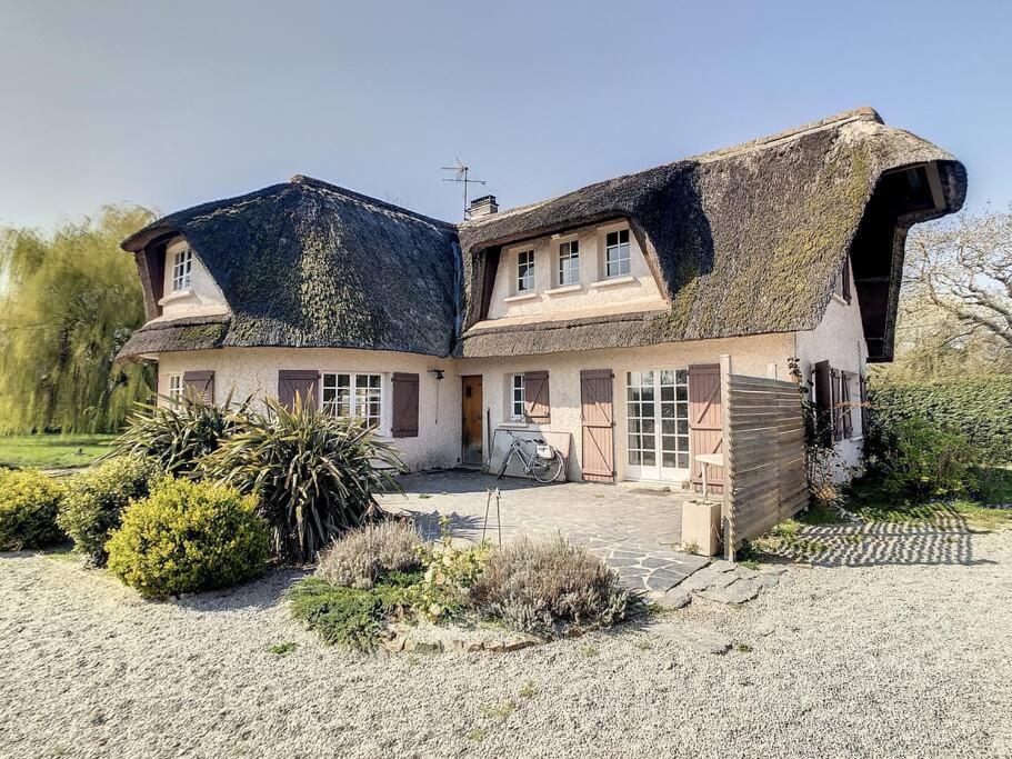 Cette grande maison est dotée d'un toit de chaume. dans l'établissement Maison de vacances en famille, à Agon-Coutainville
