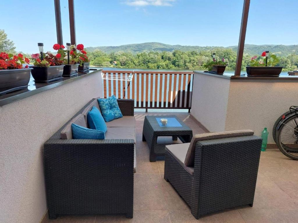 einen Balkon mit 2 Korbstühlen und einem Tisch in der Unterkunft Zen Apartment in Veliko Gradište