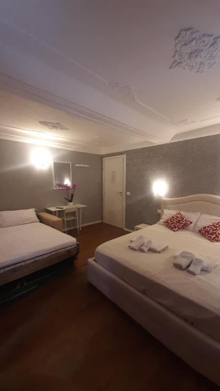 Cette chambre comprend deux lits et un bureau. dans l'établissement B&B Italian Guest Genova, à Gênes