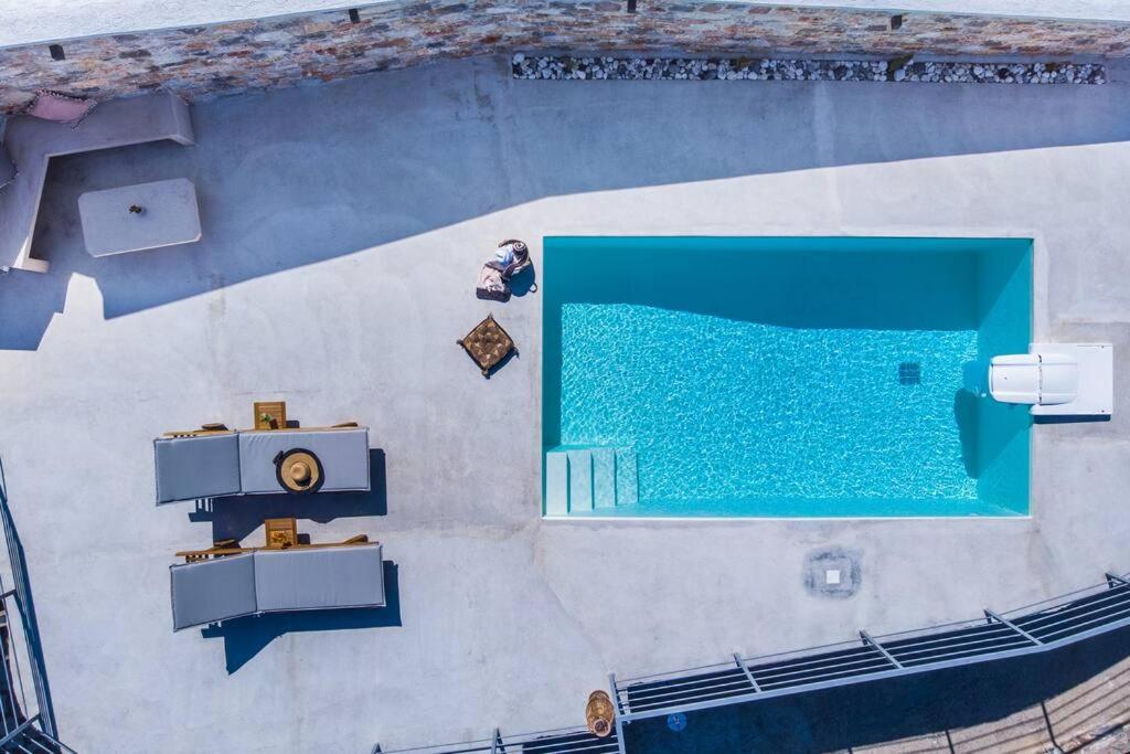 an overhead view of a swimming pool with blue water at Villa Koukounaria in Skopelos Town