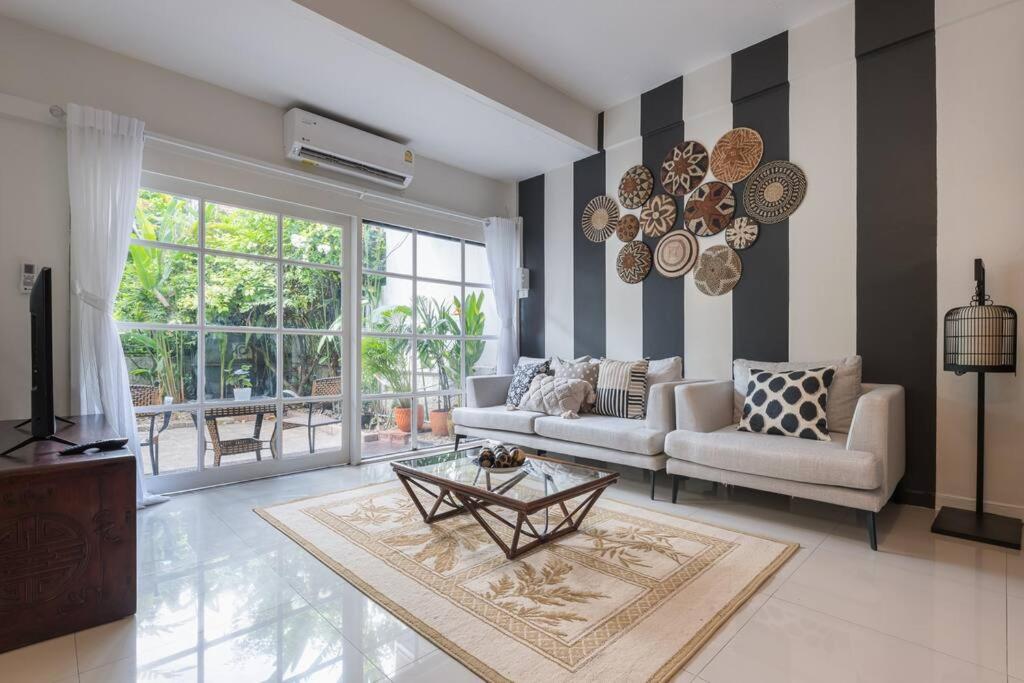 Oasis townhouse in the perfect location في بانكوك: غرفة معيشة مع أريكة وطاولة