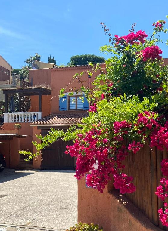 une maison avec des fleurs roses sur une clôture dans l'établissement T2 calme proche plage Bonporteau avec Clim et parking, à Cavalaire-sur-Mer