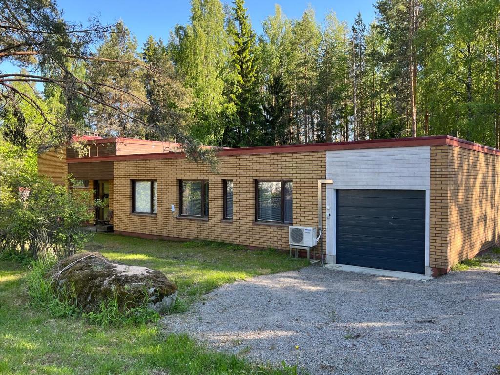 a brick house with a garage in a yard at Huoneisto karhujen kaupungissa - Tapanintien Lumo in Ähtäri