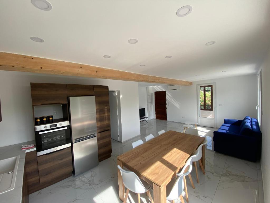 een keuken en eetkamer met een houten tafel en stoelen bij Villa, 4 chambres, jardin, Barbecue in Orange