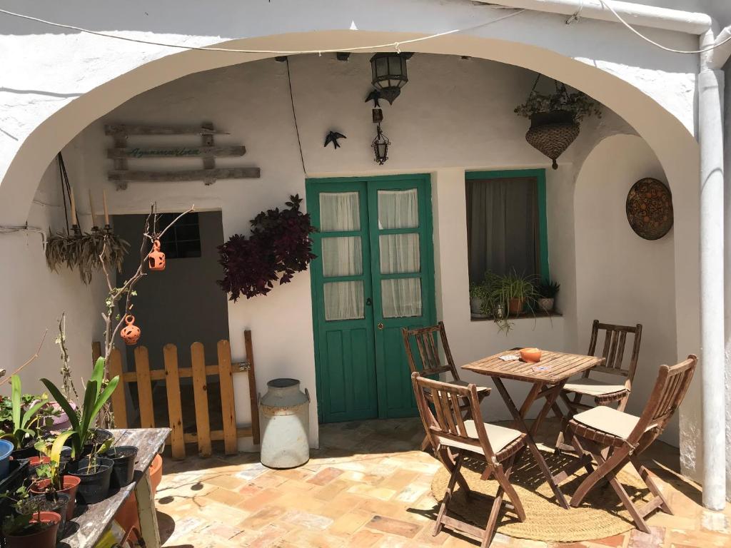 ベヘール・デ・ラ・フロンテーラにあるCasa Aguamarinaのパティオ(テーブル、椅子、緑のドア付)