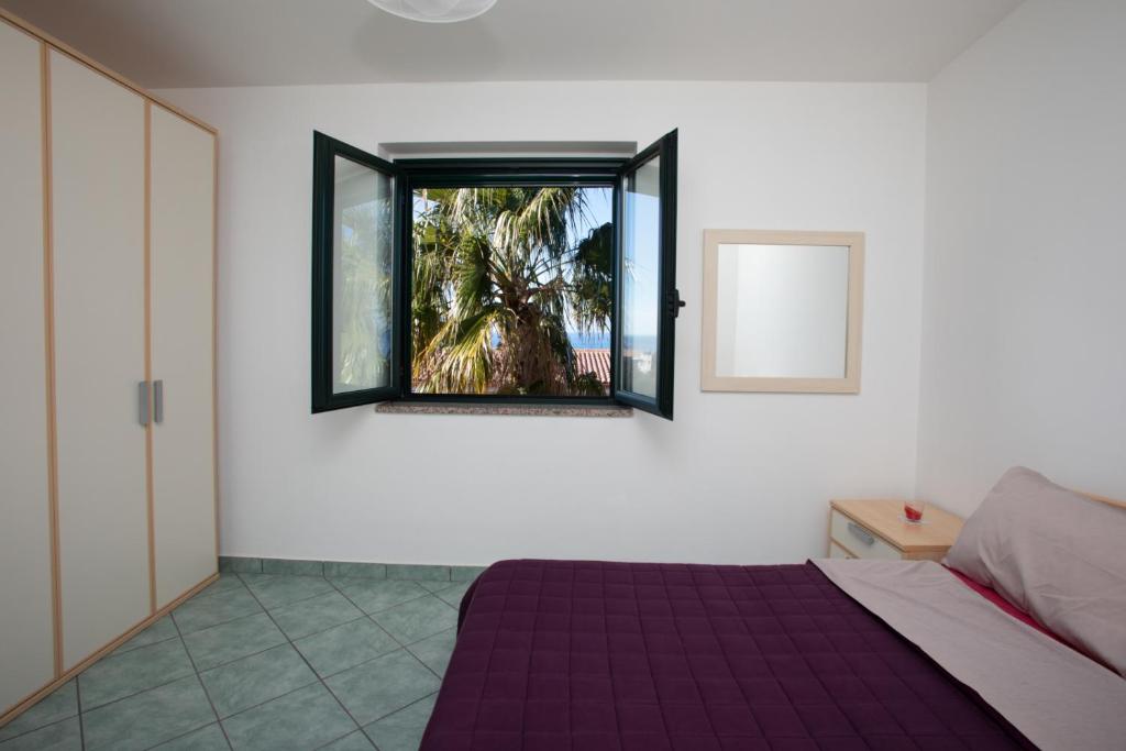 een slaapkamer met een bed en een raam bij Przytulny apartament w Belvedere Marittimo in Belvedere Marittimo