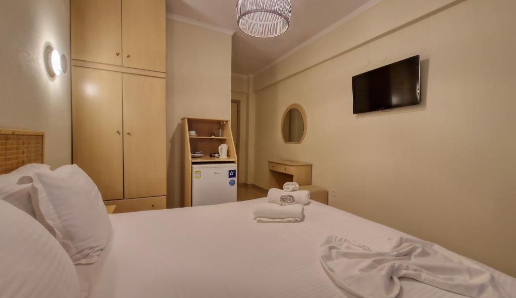 een slaapkamer met een wit bed met een handdoek erop bij Hotel Viky in Sarti