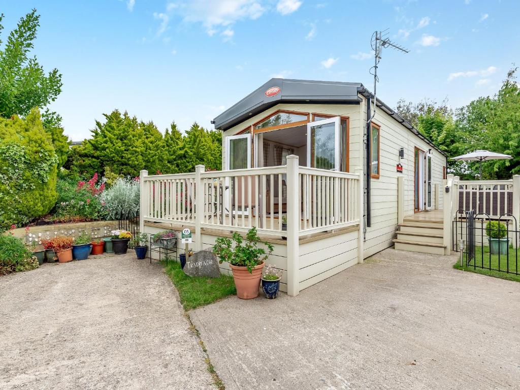 a tiny house with a porch and a deck at Tradmach Lodge in Patrington