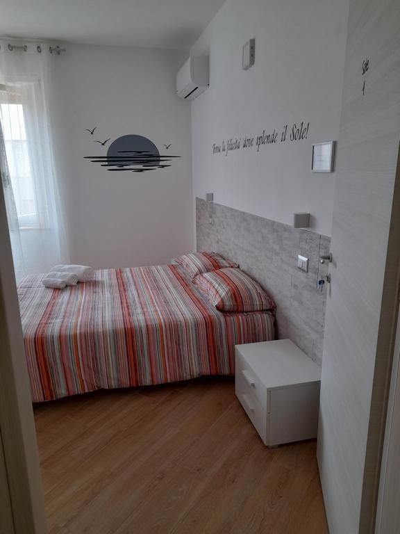 a bedroom with a bed with a striped comforter at Aer Sana in Arzana