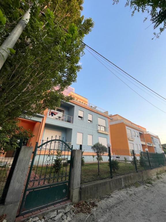 um edifício com uma cerca em frente em Emma's Apartments em Tirana