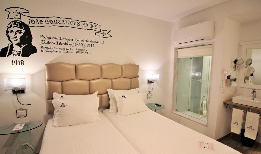 1 dormitorio con 1 cama y un cartel en la pared en Villa Ana Margarida Hotel, en Ericeira
