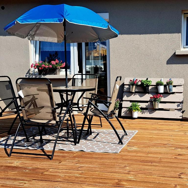 a table and chairs with an umbrella on a patio at le refuge du bonheur in Bitche