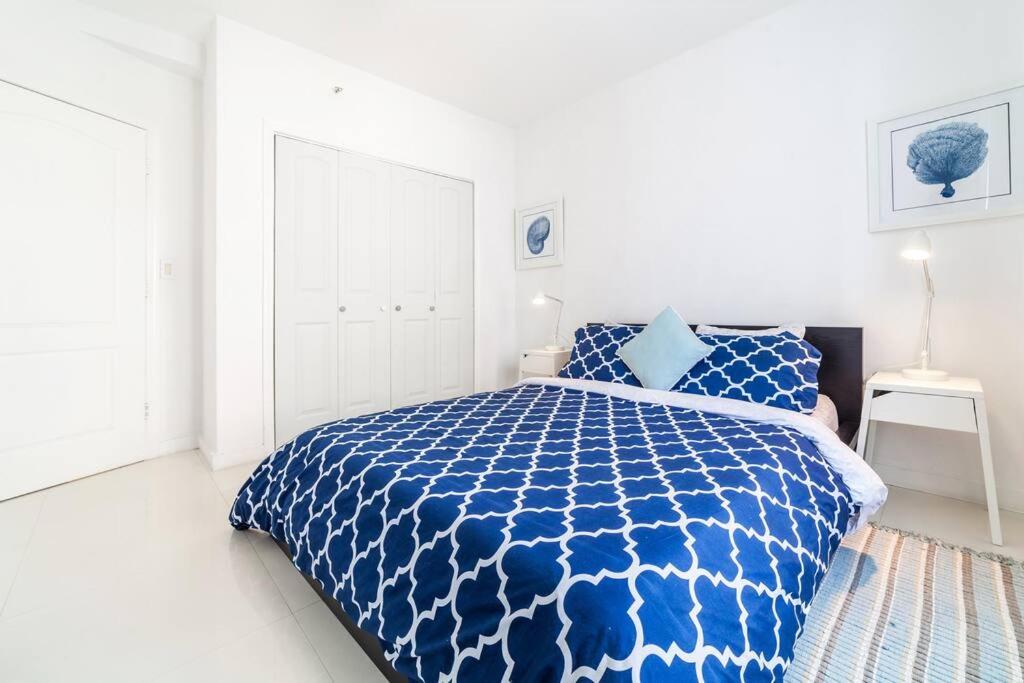a blue and white bed in a white bedroom at 2 BEDROOM ON THE BEACH ! in Miami Beach