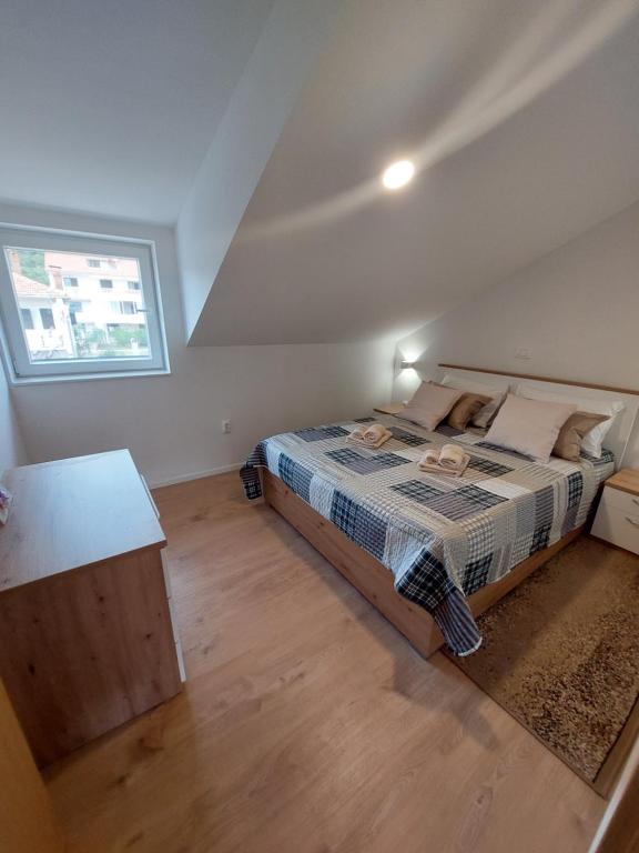 um quarto com uma cama e uma janela em Apartmani Elisa em Stari Grad
