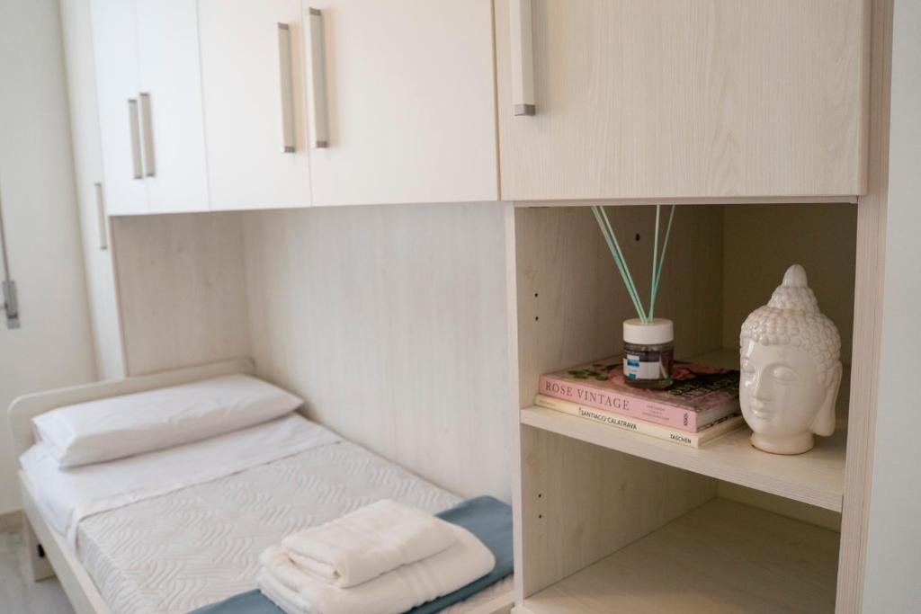 een kamer met witte kasten en handdoeken op een plank bij Cielo Mare in Viareggio