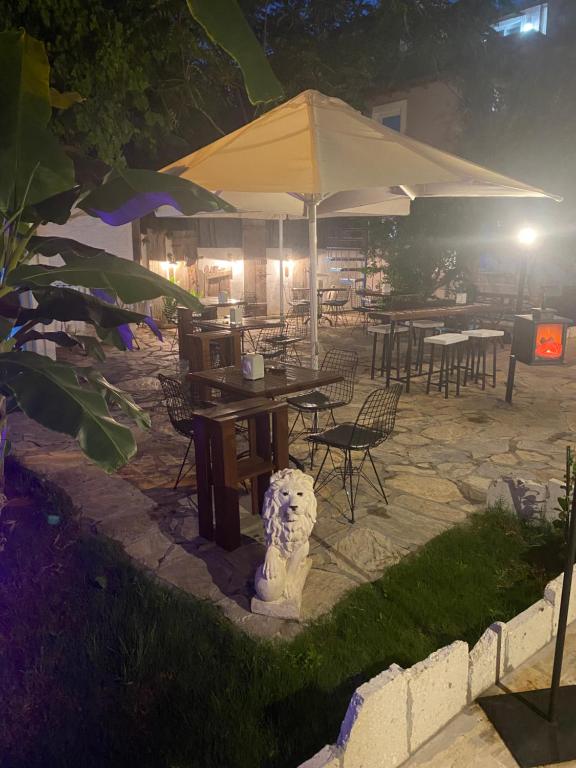 un patio con tavoli, sedie e ombrellone di Mavi Butik Apart a Çeşme