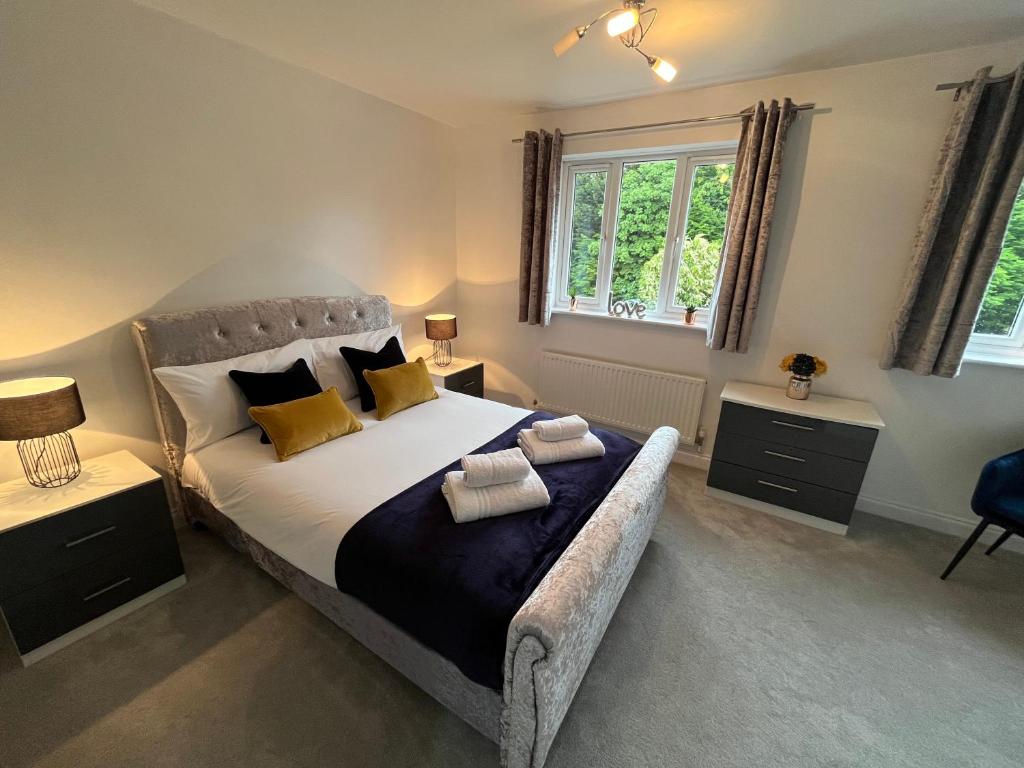 a bedroom with a large bed with yellow pillows at The Heathers - Spacious 3 Bed Home From Home in Burton upon Trent