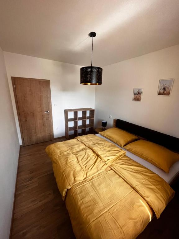 a bedroom with a large bed and a chandelier at Apartmán Kašperák in Kašperské Hory