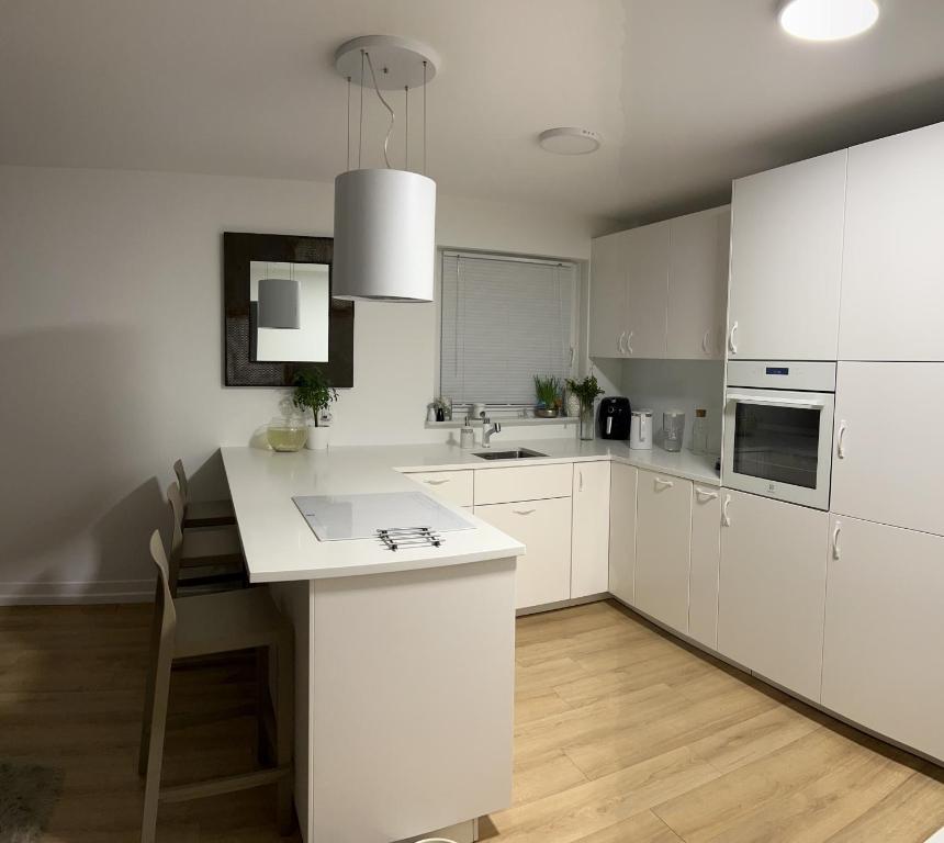 kuchnia z białymi szafkami i białym blatem w obiekcie Duże mieszkanie blisko plaży w Gdańsku