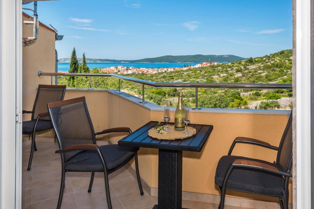 a table and chairs on a balcony with a view at Apartman Enzzo in Šibenik
