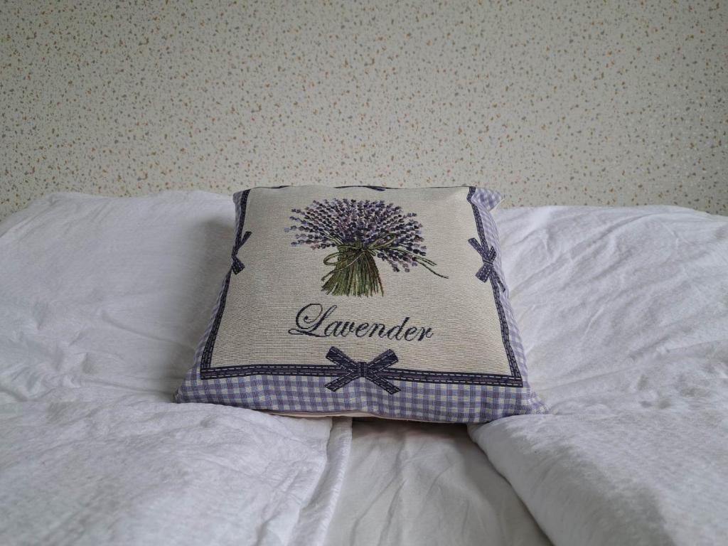 a pillow with the word lavender on it sitting on a bed at Levander Apartman in Balatonföldvár