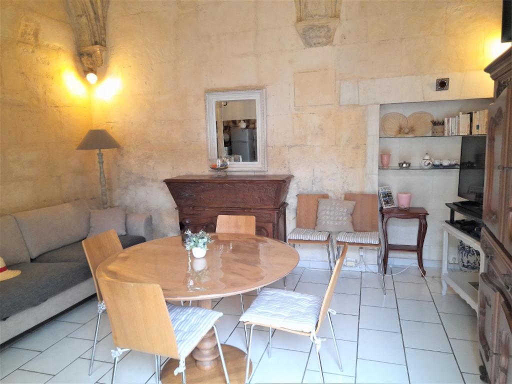 ein Wohnzimmer mit einem Tisch, Stühlen und einem Sofa in der Unterkunft La maison de Toinette in Arles