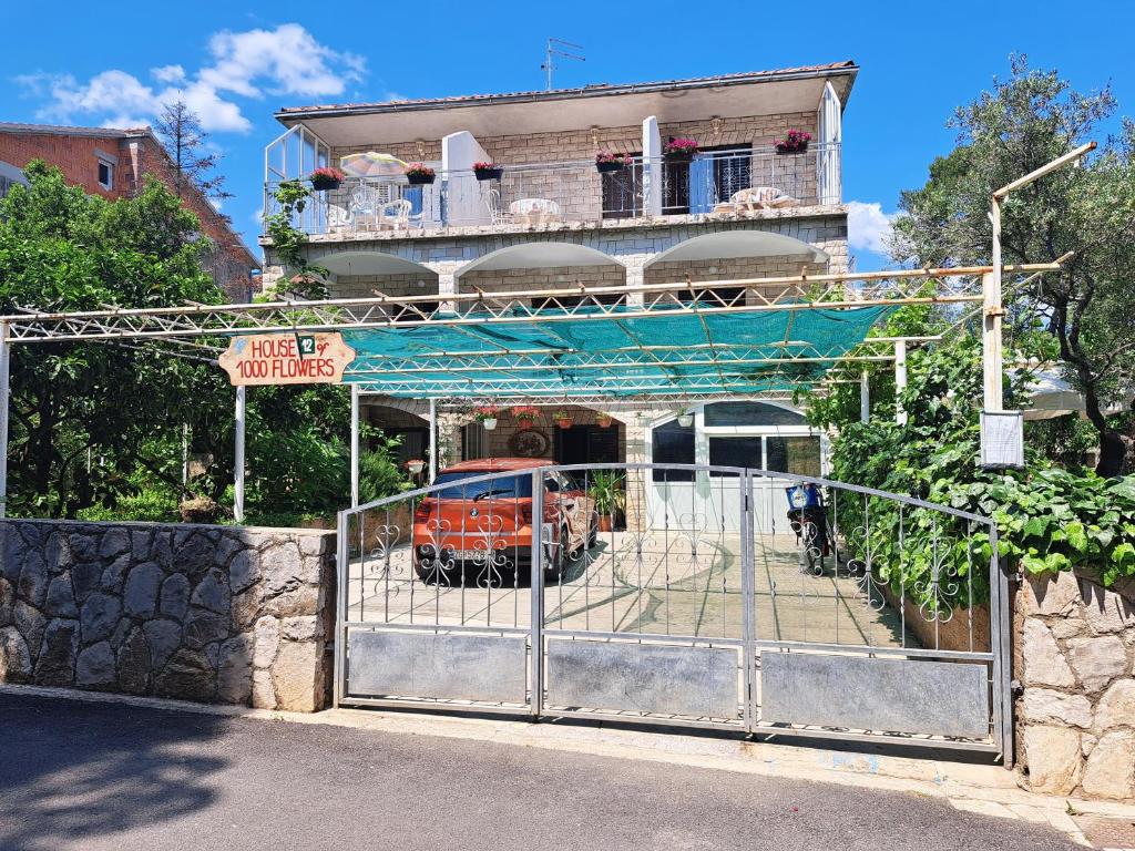 une porte en face d'un bâtiment avec une voiture à l'intérieur dans l'établissement Apartments 1000 Flowers, à Stari Grad