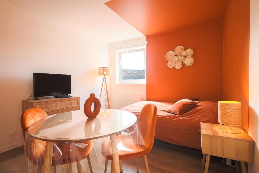Cette petite chambre comprend une table et un lit. dans l'établissement Charmant Studio bohème en centre ville, à Saint-Brieuc