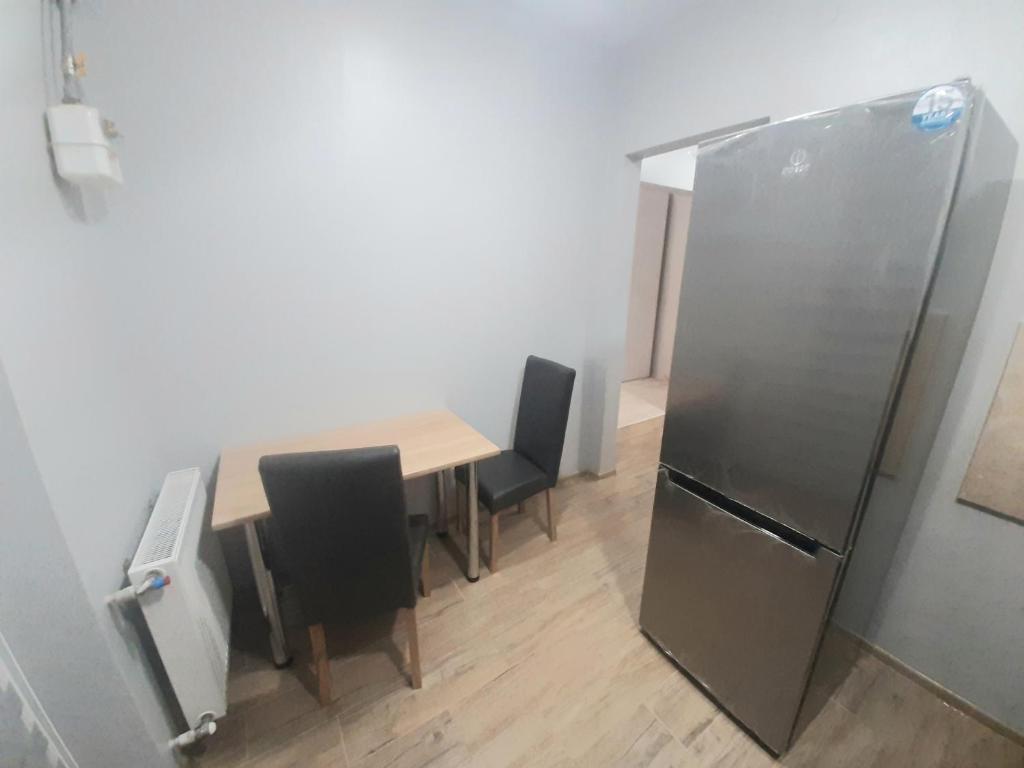 ein Esszimmer mit einem Tisch und einem Kühlschrank in der Unterkunft Apart Pro in Uschhorod