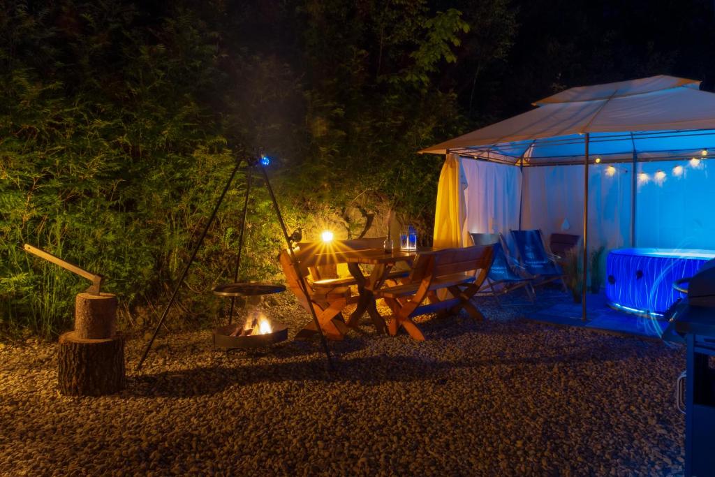 a picnic table and a tent at night at Ostoja Gorce in Nowy Targ