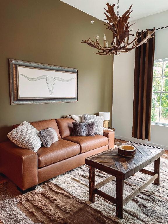 Hotel Cozy Cabin - 2 Miles to Broadway & Free Parking, a living room with a brown couch and a table at Cozy Cabin - 2 Miles to Broadway & Free Parking in Nashville