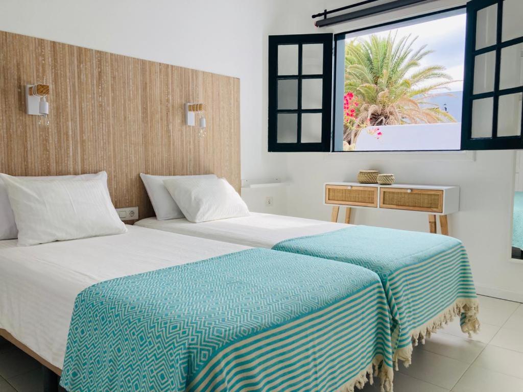 two beds in a room with a view of the ocean at Apartamento Aqua Clara in Puerto del Carmen