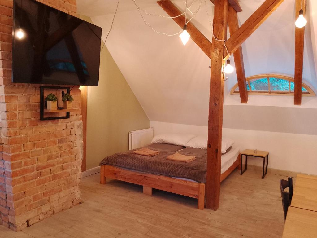 a bedroom with a bed and a tv in a attic at Apartamenty Pod Sosnami in Sopot