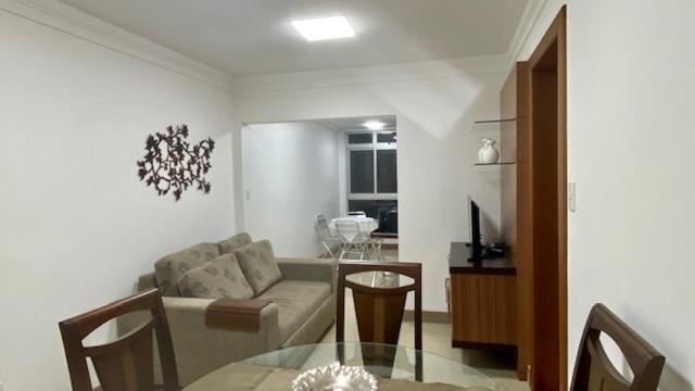 ein Wohnzimmer mit einem Sofa und einem Glastisch in der Unterkunft Luxuoso a 250 Mts da Praia in Guarapari