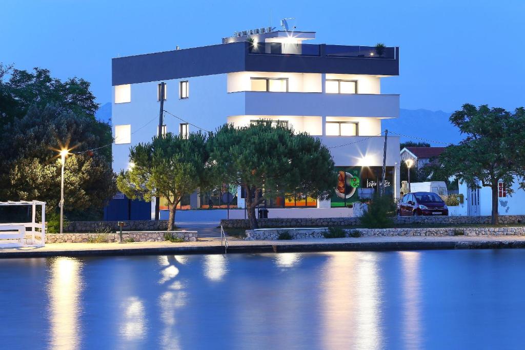 un edificio junto a un río con un edificio en Apartments Bonaca with Jacuzzi en Privlaka