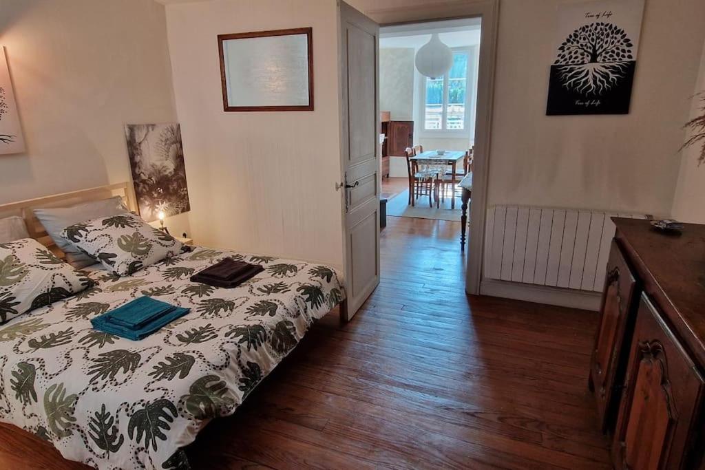 a bedroom with a bed and a dining room at Appartement dans Maison de ville - 4 personnes in Oloron-Sainte-Marie