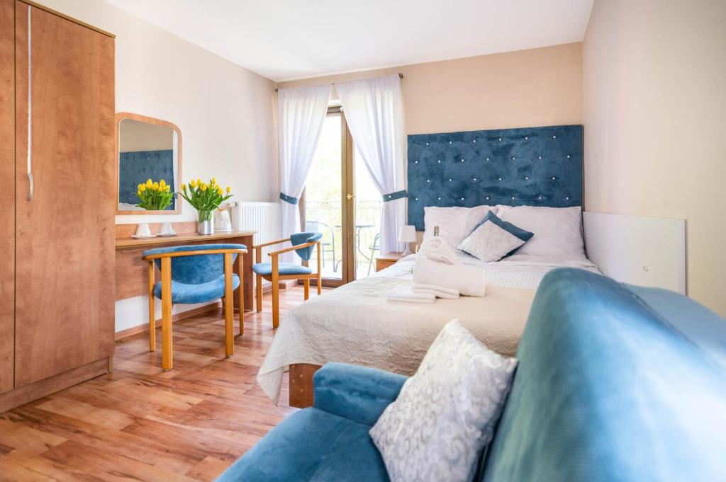 sypialnia z łóżkiem i niebieską kanapą w obiekcie ReveliQa w Pobierowie