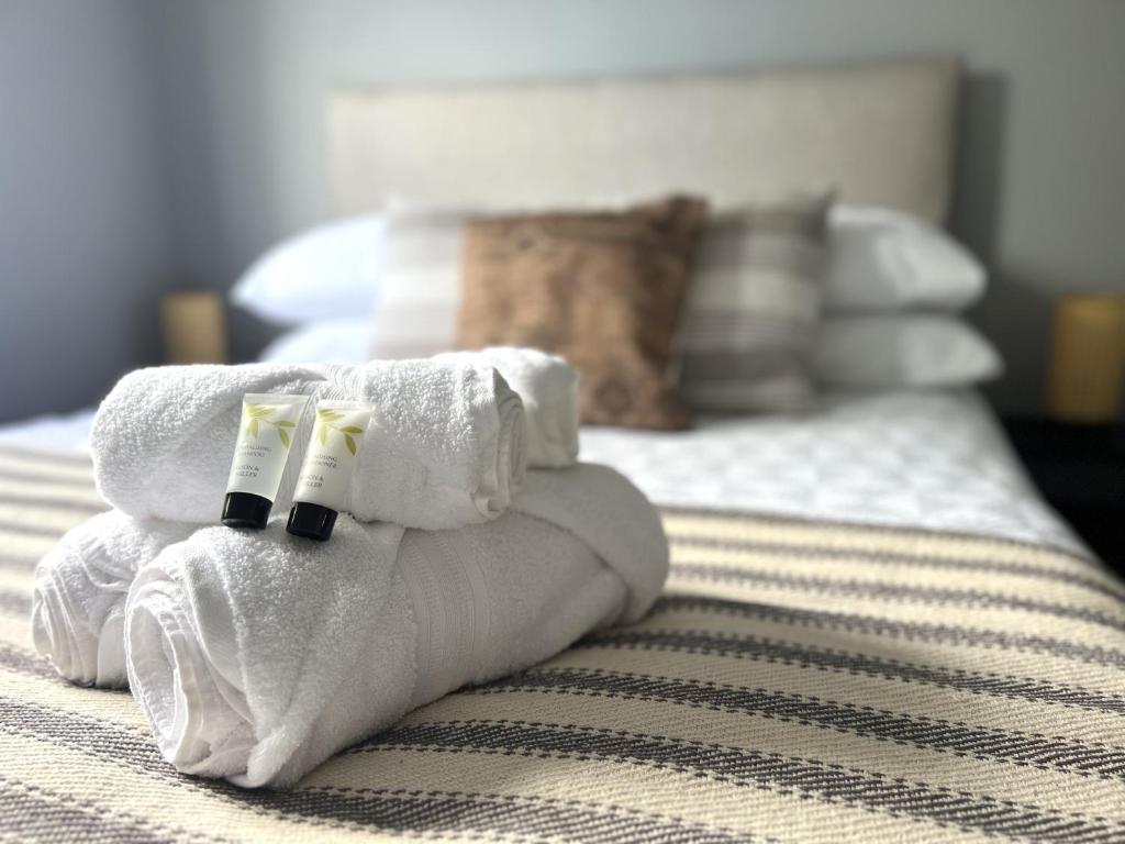 a pile of towels sitting on top of a bed at Franklin Suite - Reading City Centre - Free Parking - Close to Station in Reading