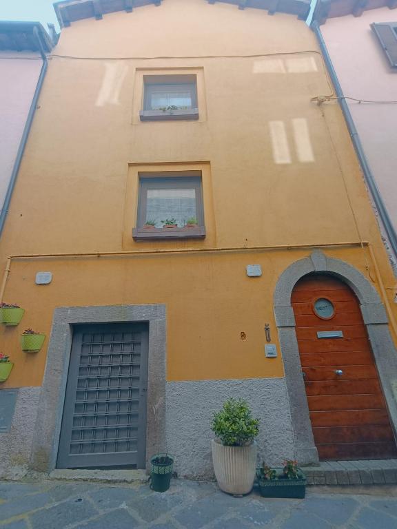 a yellow building with two windows and two doors at Numero VENTI in Montefiascone