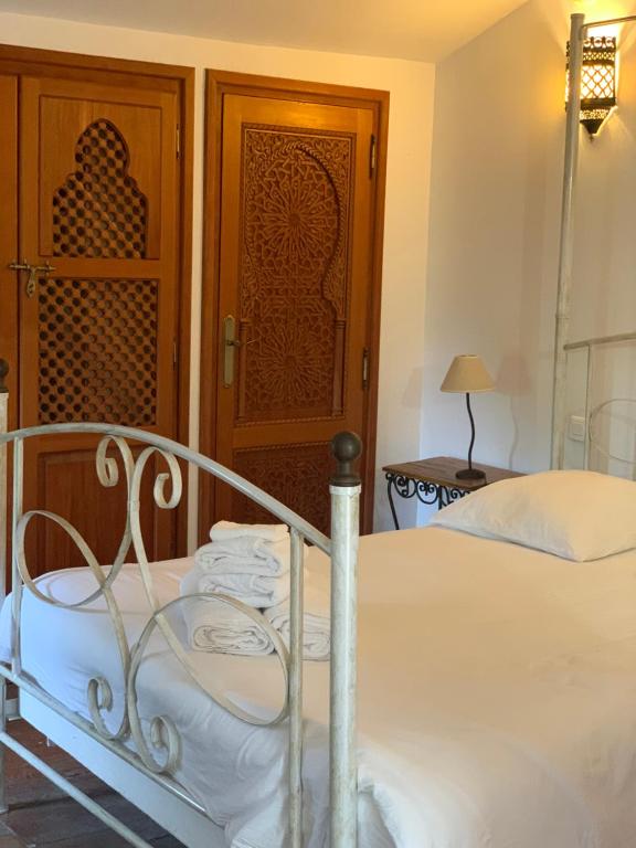 a bedroom with a bed and a wooden door at Château Sainte Colombe in Saint-Geniès-des-Mourgues