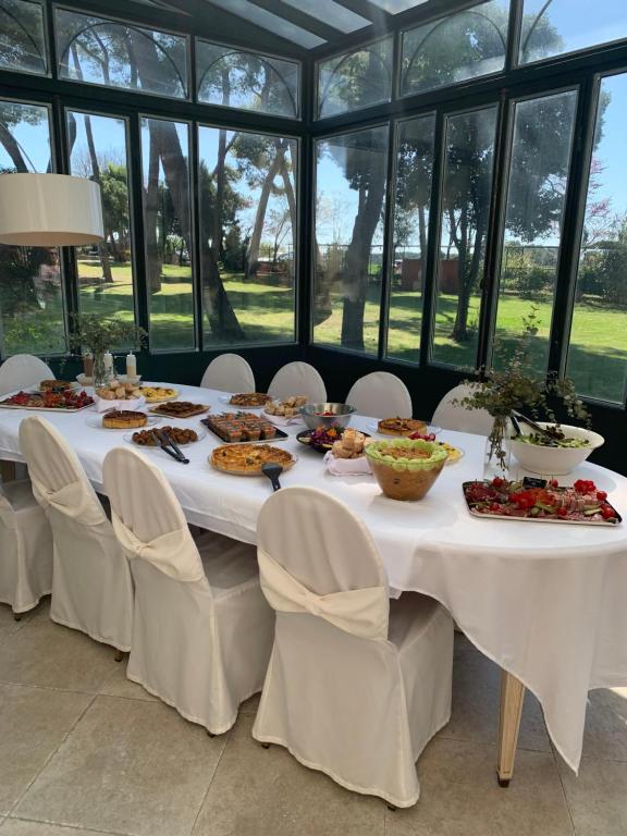 a table with food on it in a room with windows at Château Sainte Colombe in Saint-Geniès-des-Mourgues