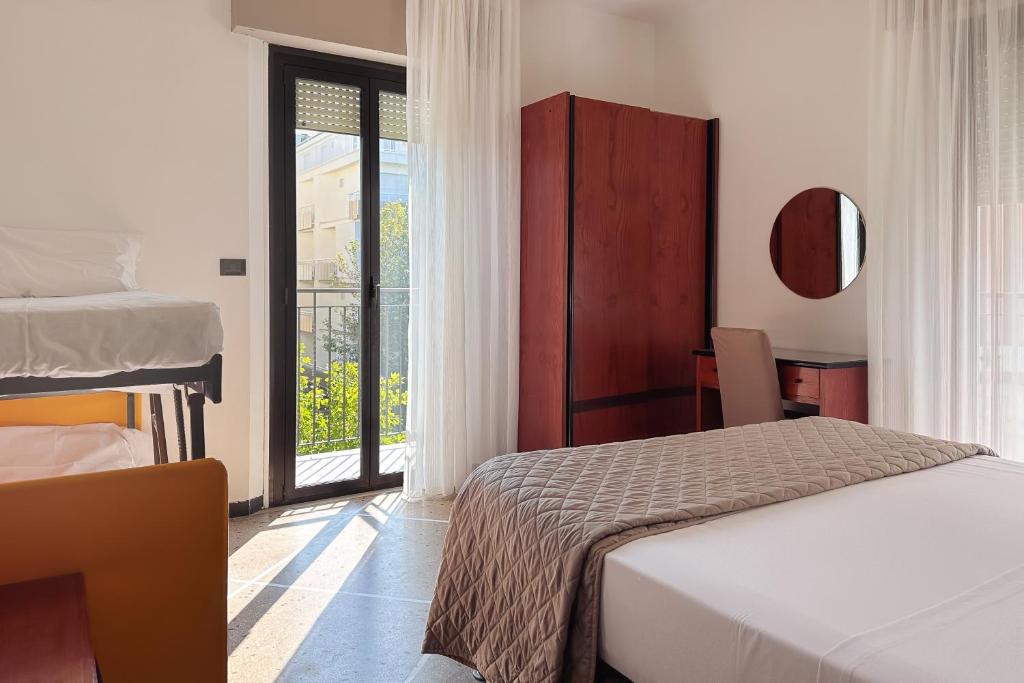 a hotel room with a bed and a window at Lime Hotel in Rimini