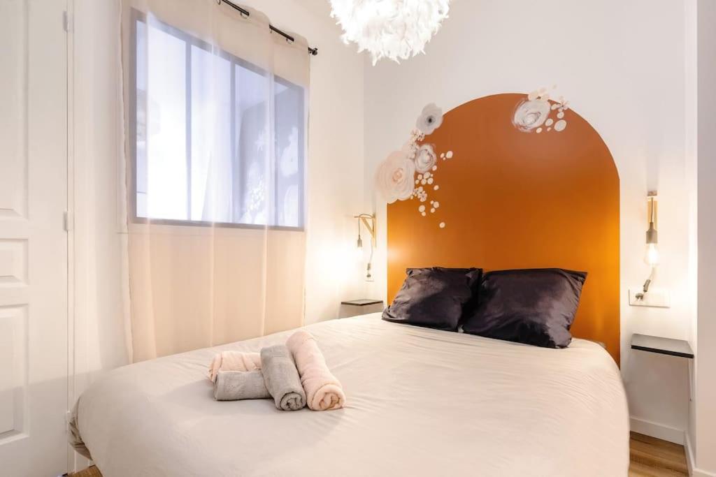sypialnia z dużym łóżkiem z pomarańczowym zagłówkiem w obiekcie Charmant 2 pièces, 2 couchages séjour glamour w Amiens