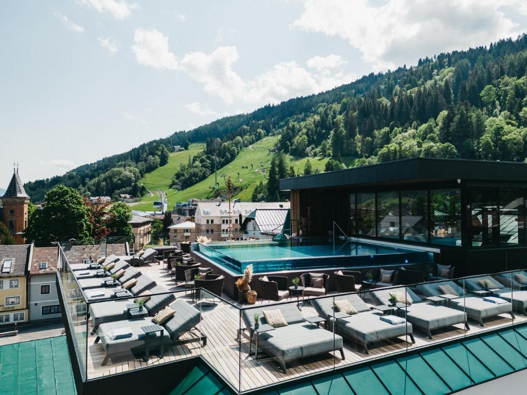 a pool on the roof of a building with chairs at JOHANN Schladming in Schladming