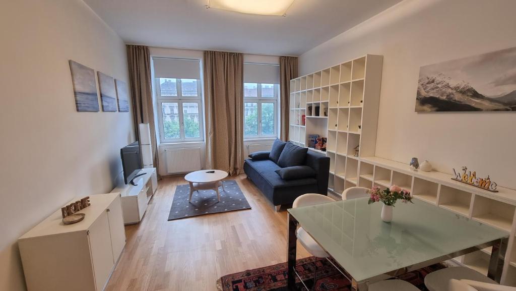 sala de estar con sofá azul y mesa en Sunny Apartment next to Metro 1BR, en Viena