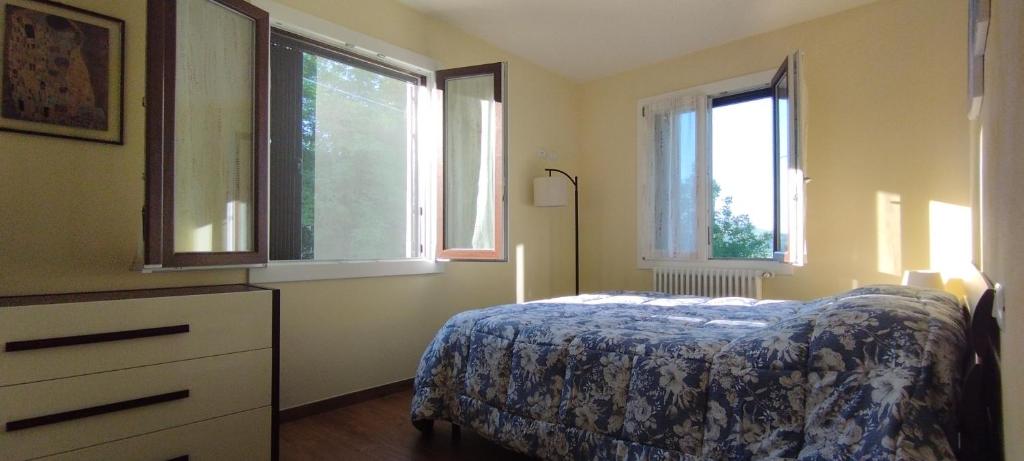 1 dormitorio con 1 cama y 2 ventanas en La Quagnola splendida casa in Appennino, en Polinago