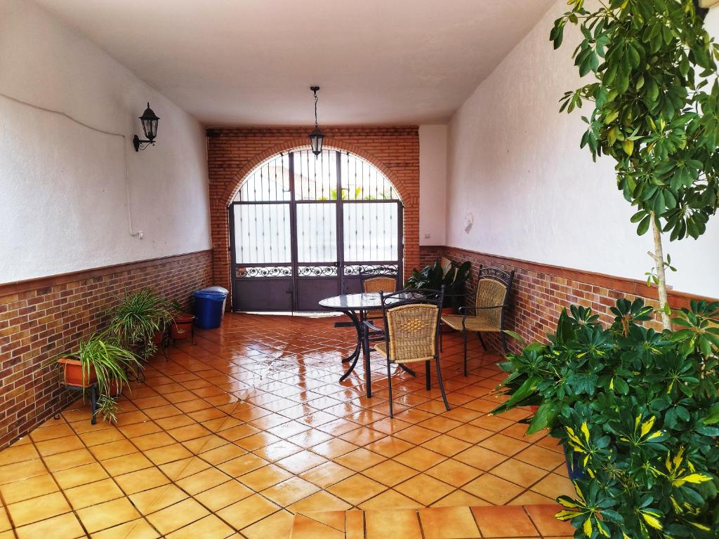 Habitación con mesa, sillas y pared de ladrillo. en Retiro del Bullaque, en El Robledo