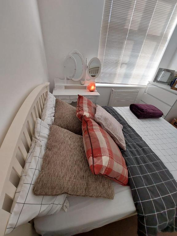 uma cama com almofadas num quarto em Nice and comfortable Shared Flat in Surbiton em Malden